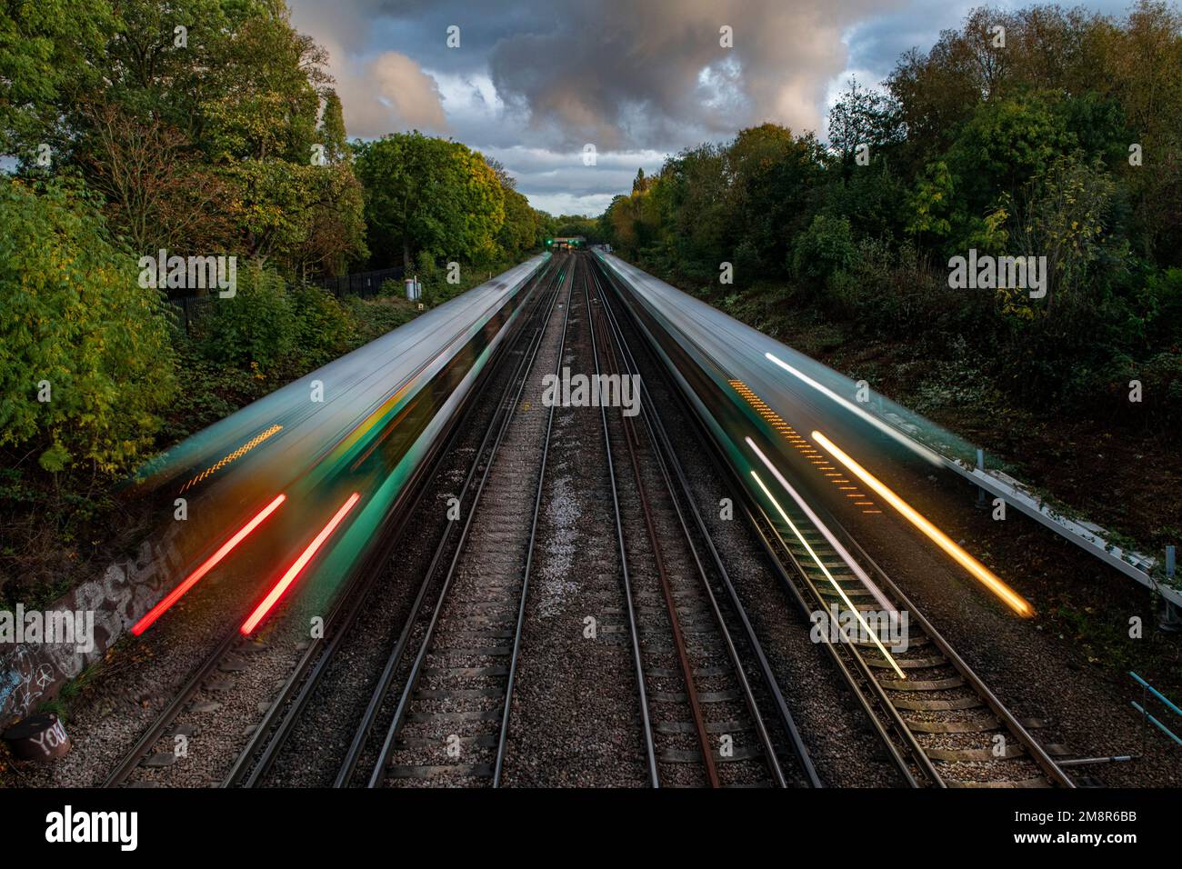 I treni si dirigono verso Brighton da Victoria sotto un tramonto incantevole Foto Stock