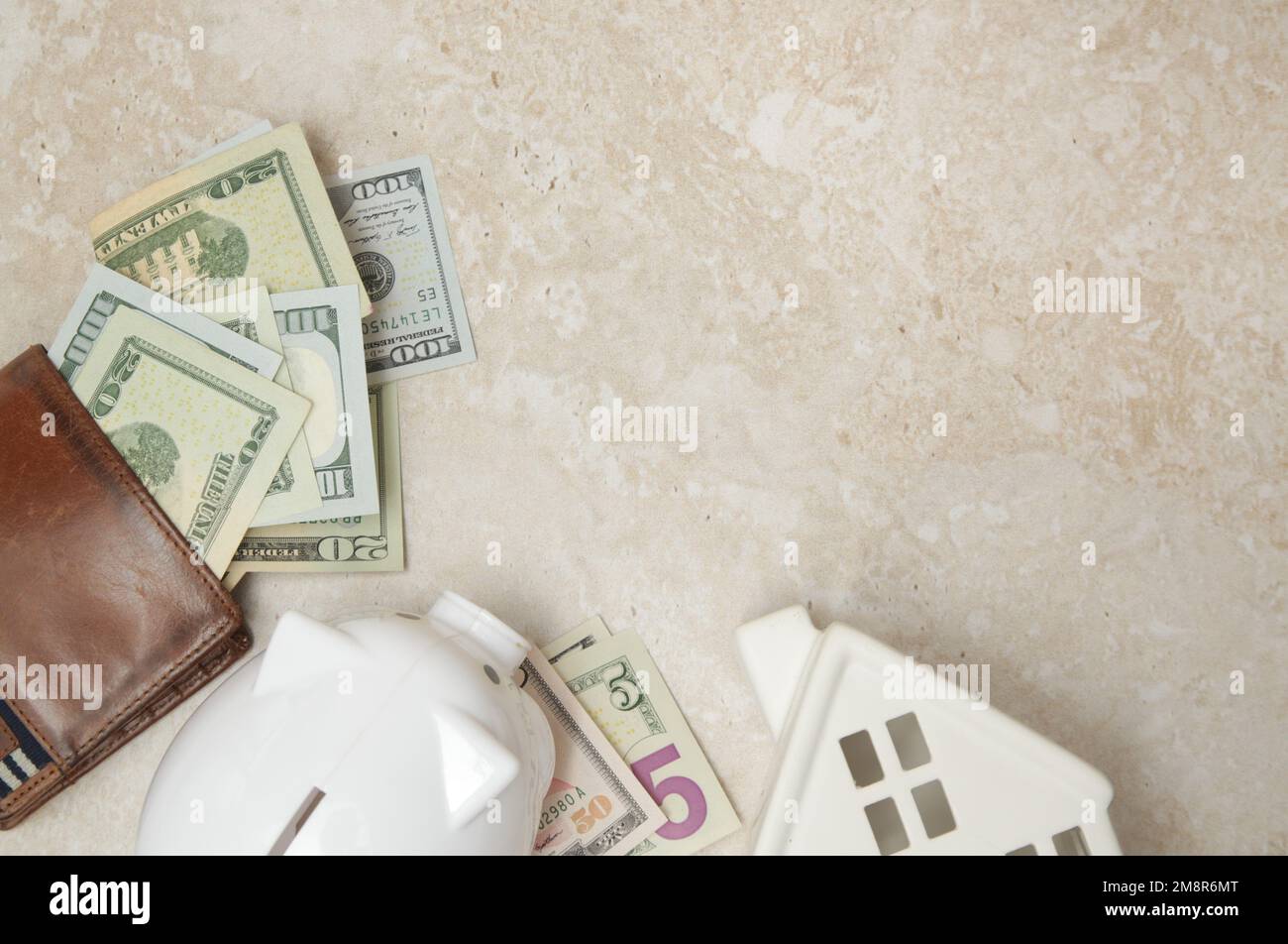 Pianificazione del budget domestico. Costo della vita. Concetto di inflazione. Concetto di risparmio di denaro per l'acquisto di nuova casa. Piggy bank, portafoglio con banconote in dollari e mese Foto Stock