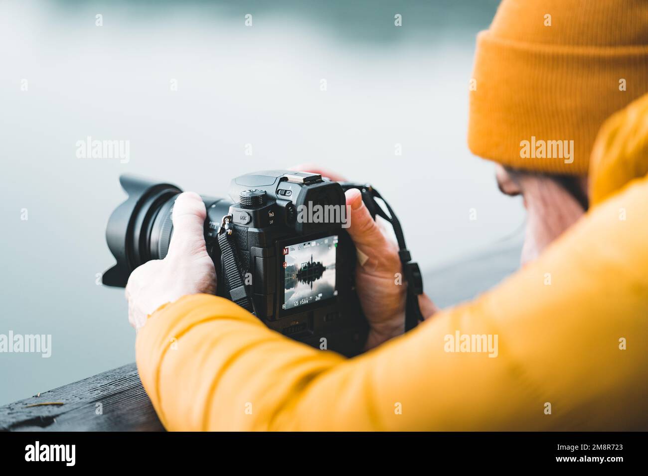 Fotografa utilizzando lo schermo lcd posteriore per comporre e scattare una foto di un paesaggio Foto Stock