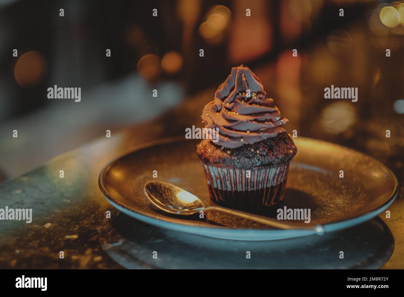 Cupcake al cioccolato con crema di cacao sul banco di marmo della caffetteria. Foto Stock