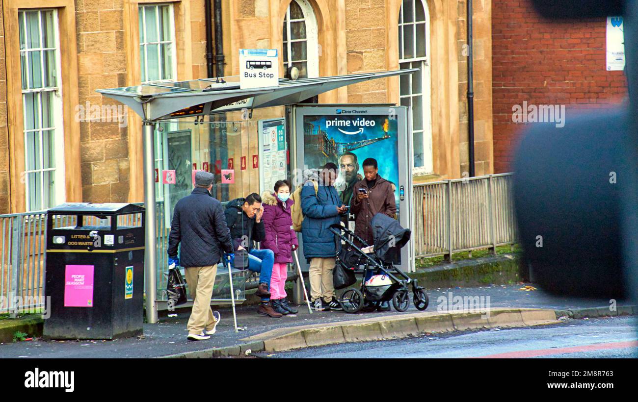 Glasgow, Scozia, Regno Unito 15th gennaio 2023. Il tempo del Regno Unito: I poveri alla fermata dell'autobus bagnato e ventoso hanno visto le strade umide miserabili come è uscito questa settimana l'aspettativa di vita per la gente del posto è stata la più bassa nel regno unito a 74. La scarsa proprietà delle auto significa che i poveri si affidano agli autobus, insieme a cattive condizioni di salute e disabilità che si rifà in città con benefici per gli utenti del bastone. Credit Gerard Ferry/Alamy Live News Foto Stock