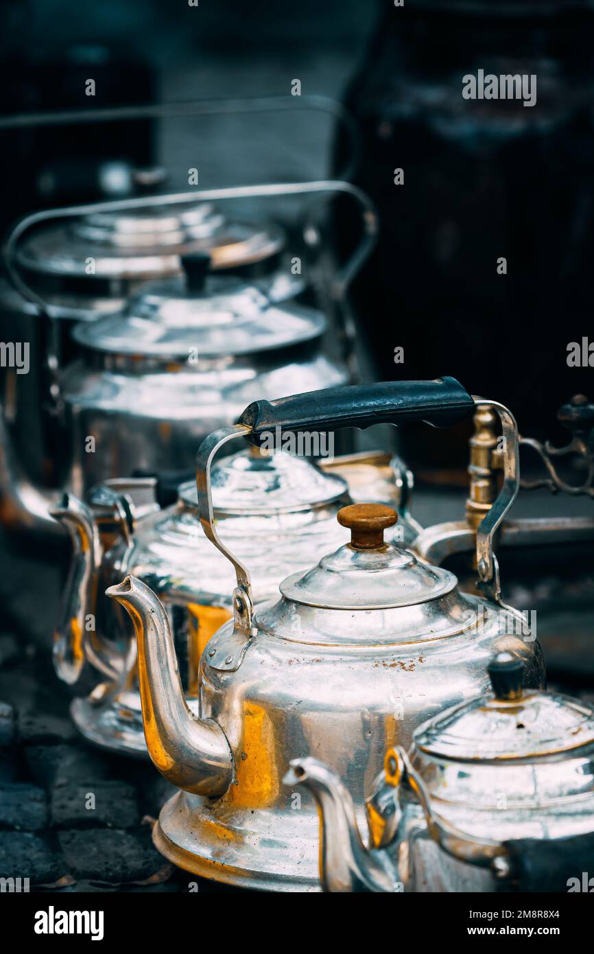 Vista ravvicinata sui Tea Pots d'epoca in metallo in una fila al mercato delle pulci. Seconda vita per le cose vecchie. Vecchi piatti per caffè e tè. Concetto di Tea Party e. Foto Stock