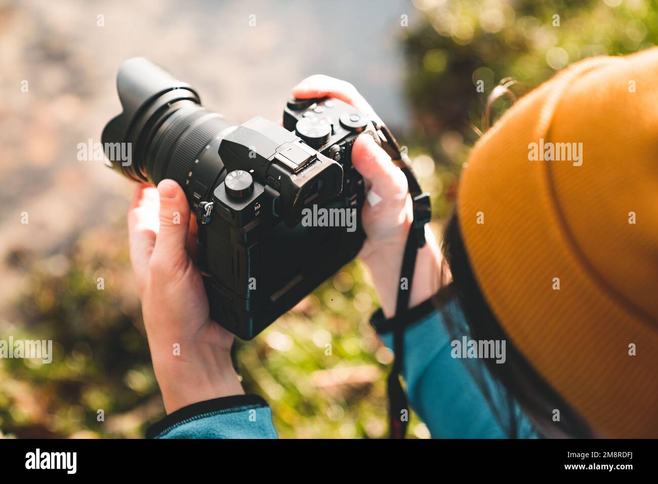 Vista laterale di un fotografo all'aperto che scatta foto di paesaggi con una fotocamera digitale Foto Stock