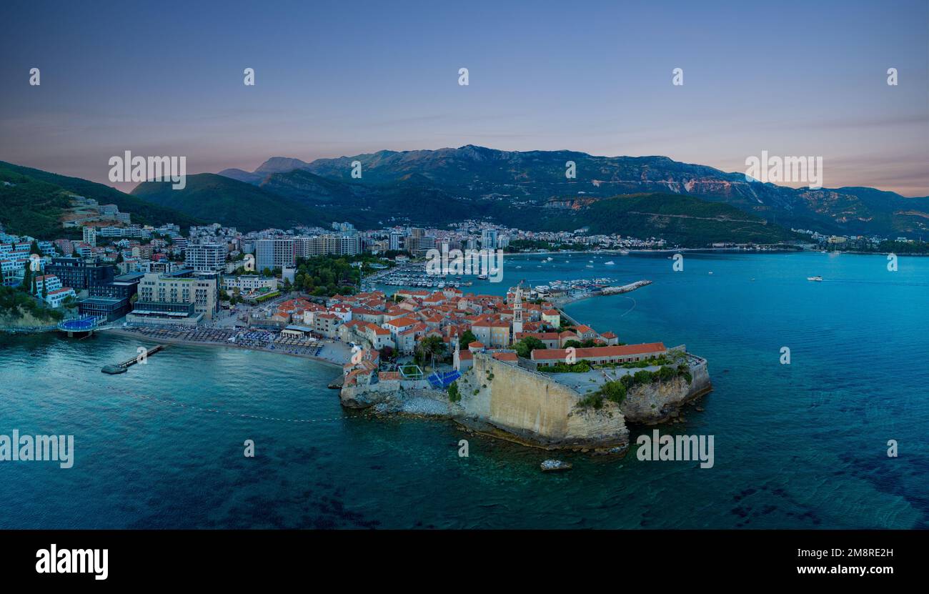 Panorama del porto marittimo con piccole navi e barche per escursioni sul mare Adriatico vicino all'antica isola storica di San Stevan al sole della sera Foto Stock