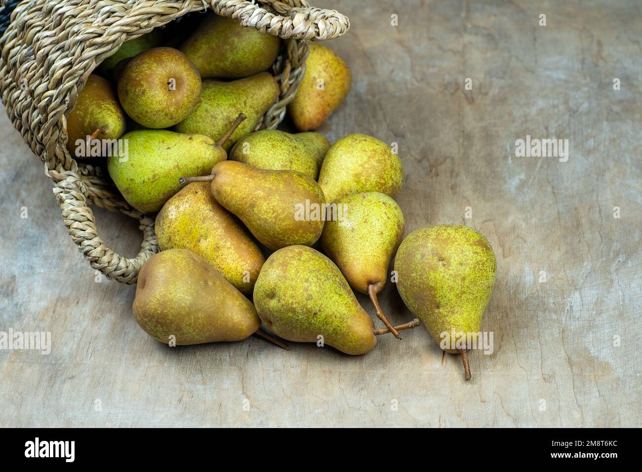 Pere in cesto su uno sfondo di legno. Raccolta di frutta. Autunno ancora vita. Pear Variety Bera Conference. Cibo vitaminico. Foto Stock