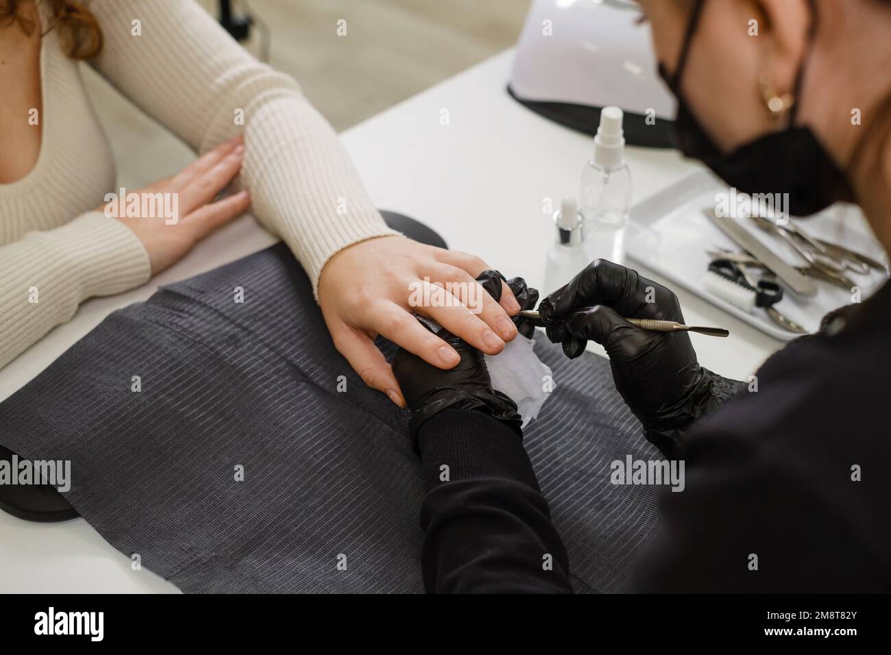 Servizio chiodi. Vista ritagliata della ragazza che ottiene le unghie fatto al salone di bellezza. Master manicure facendo unghie per il cliente donna Foto Stock