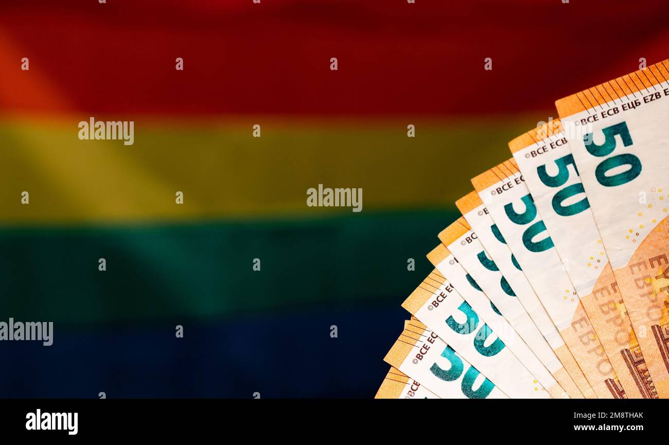 Parte di banconote da 50 euro sullo sfondo della bandiera arcobaleno. Concetto di profitto sul tema di LGBT. Foto Stock