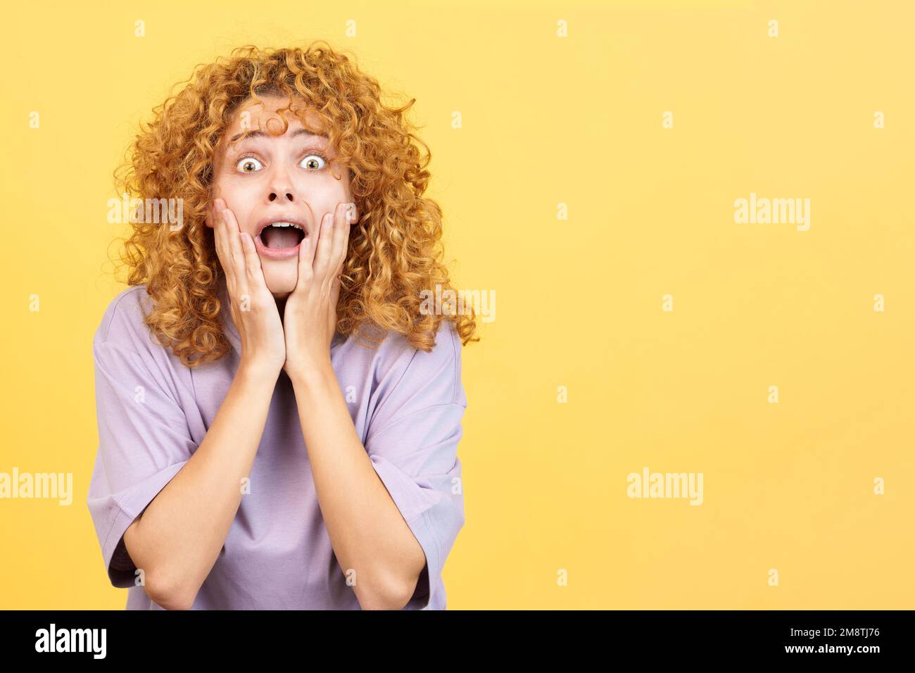 Donna con le mani sul viso che esprime sgomento Foto Stock