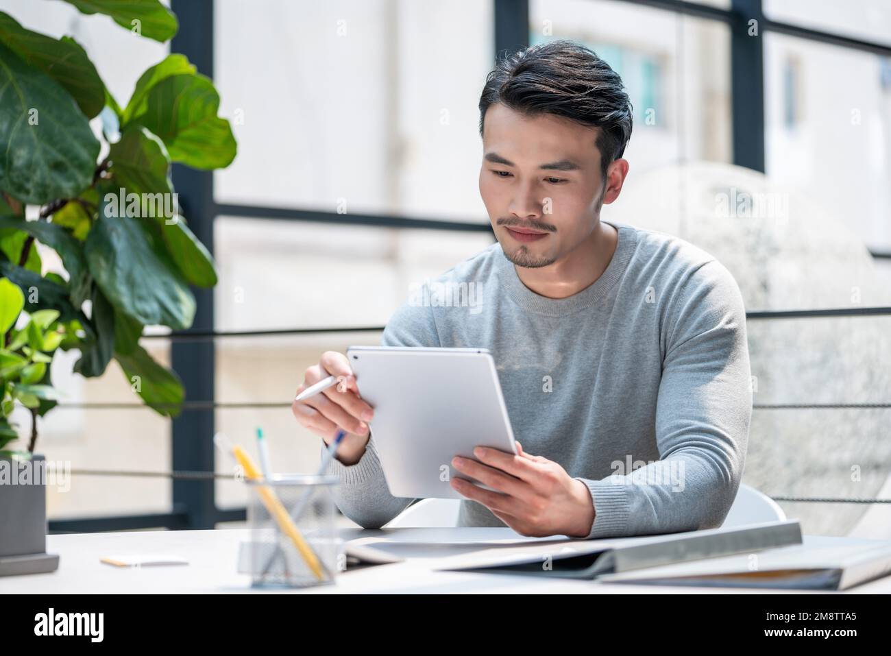 Il giovane usa le compresse Foto Stock