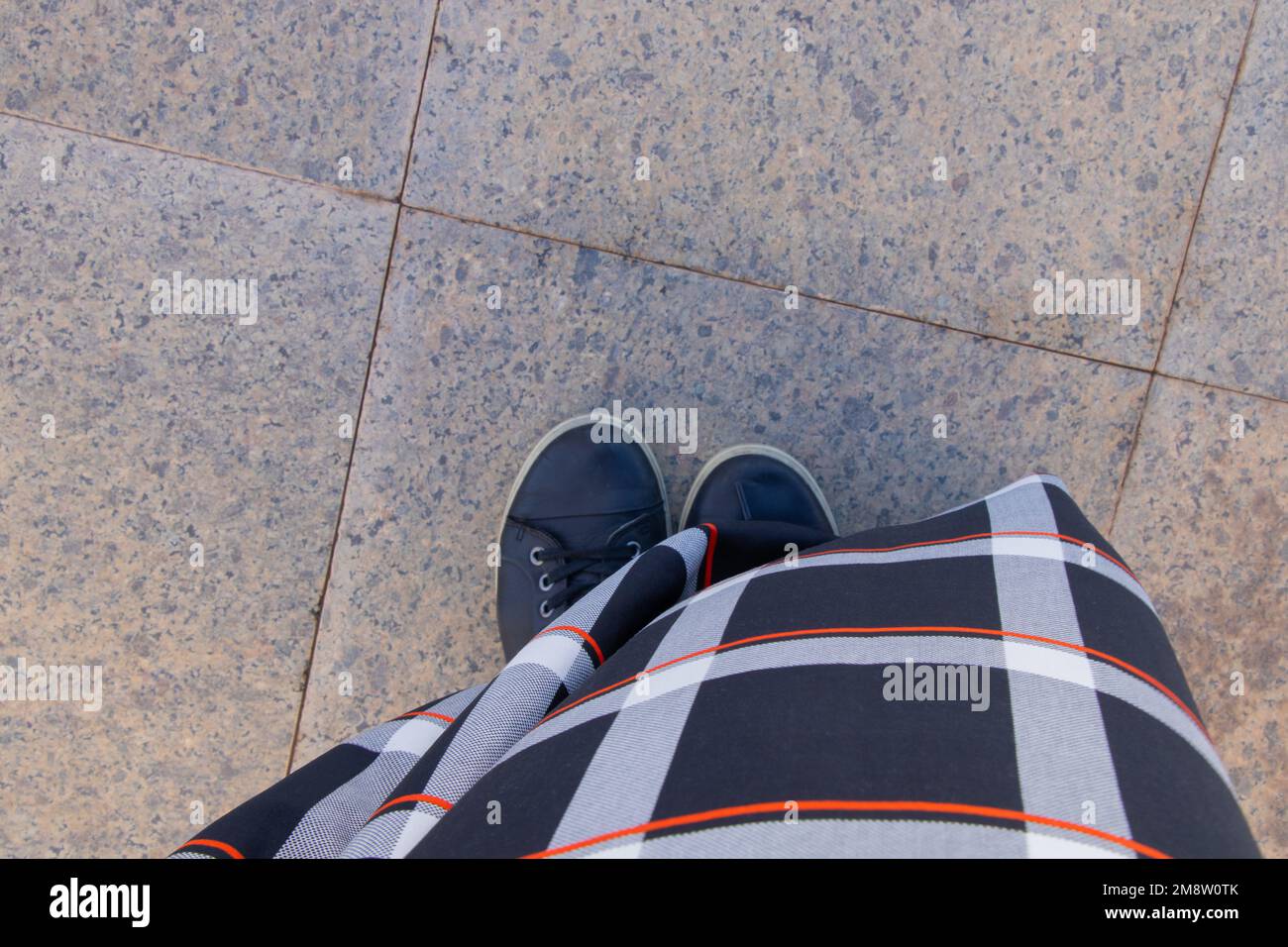 sneakers neri e un lungo vestito sul pavimento nella moschea vista dall'alto da vicino Foto Stock