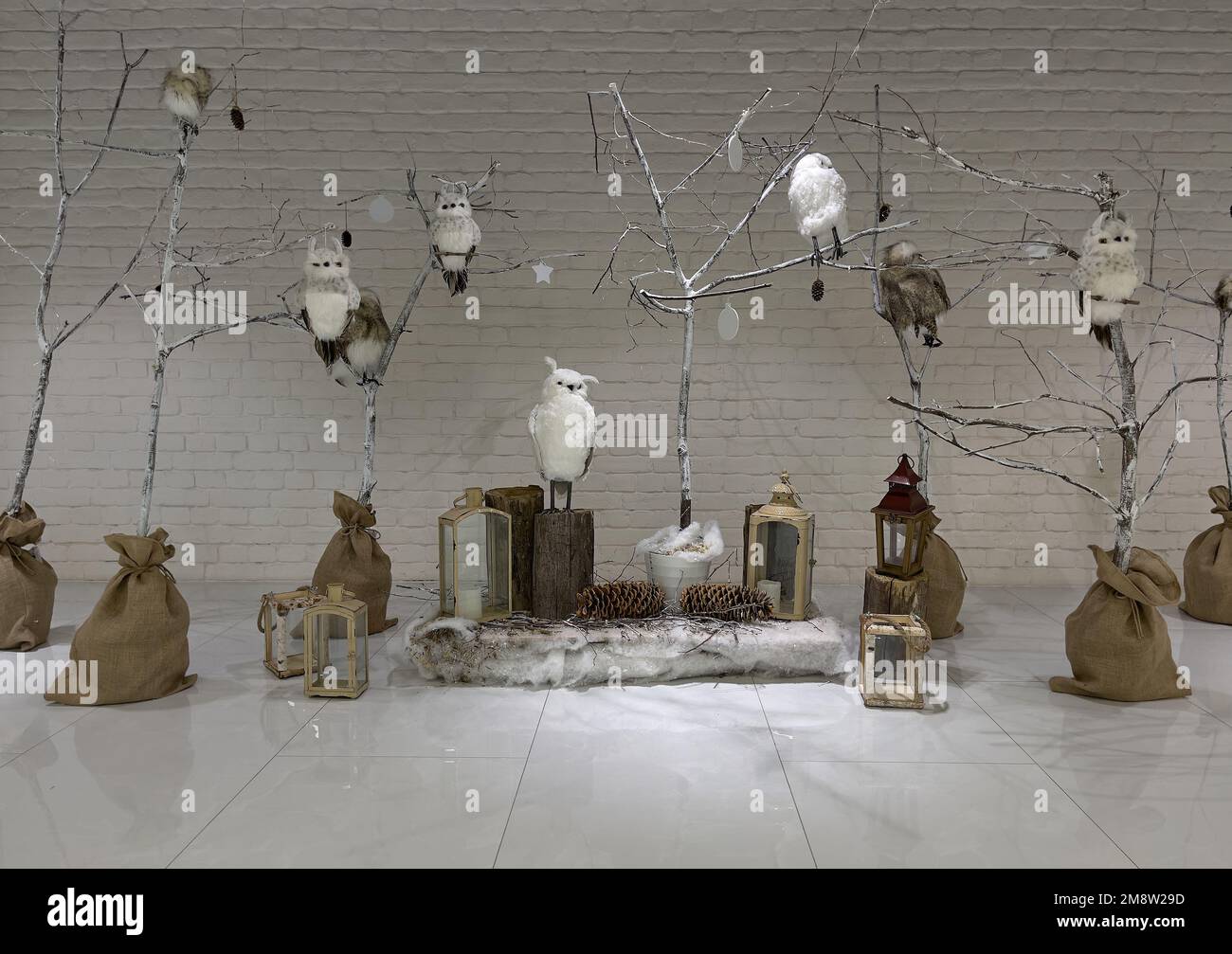 Decorazioni con gufi e rami sullo sfondo del muro. Foto Stock