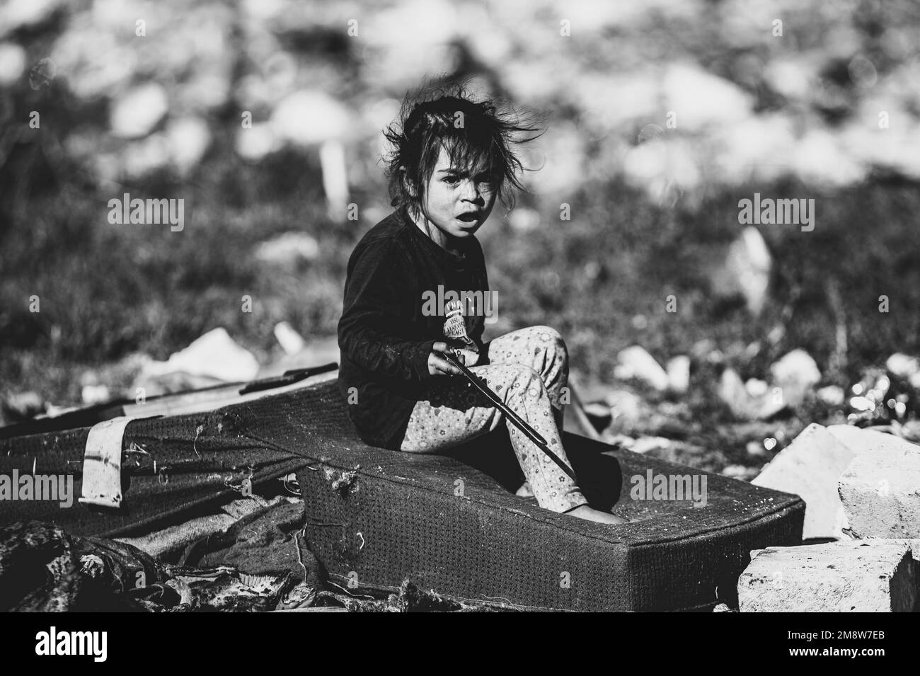 Un colpo monocromatico del bambino povero in una buca rumena il giorno del pane Foto Stock