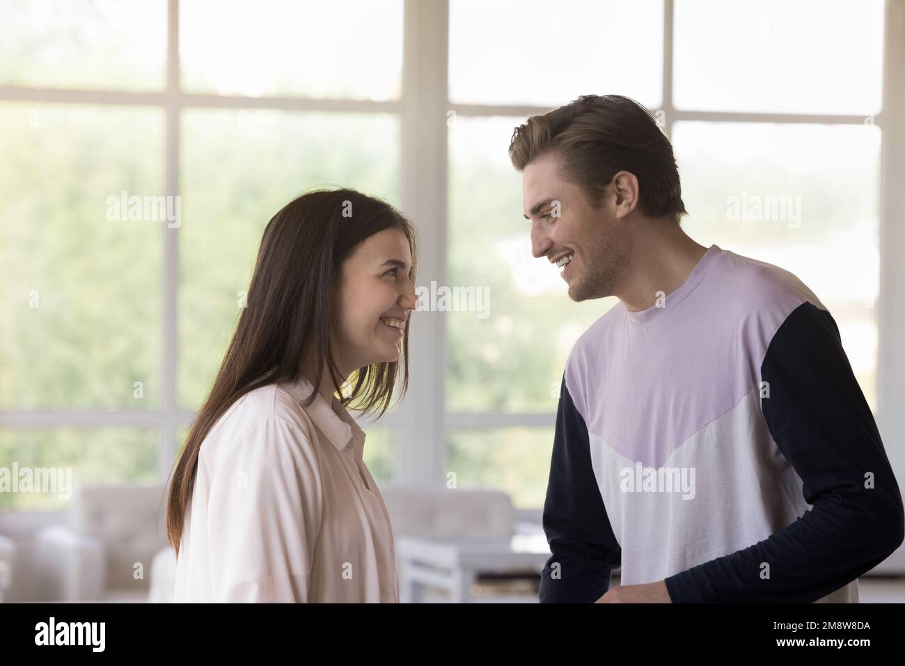 Felice giovane coppia che risale nel caffè, in piedi all'interno della lounge Foto Stock