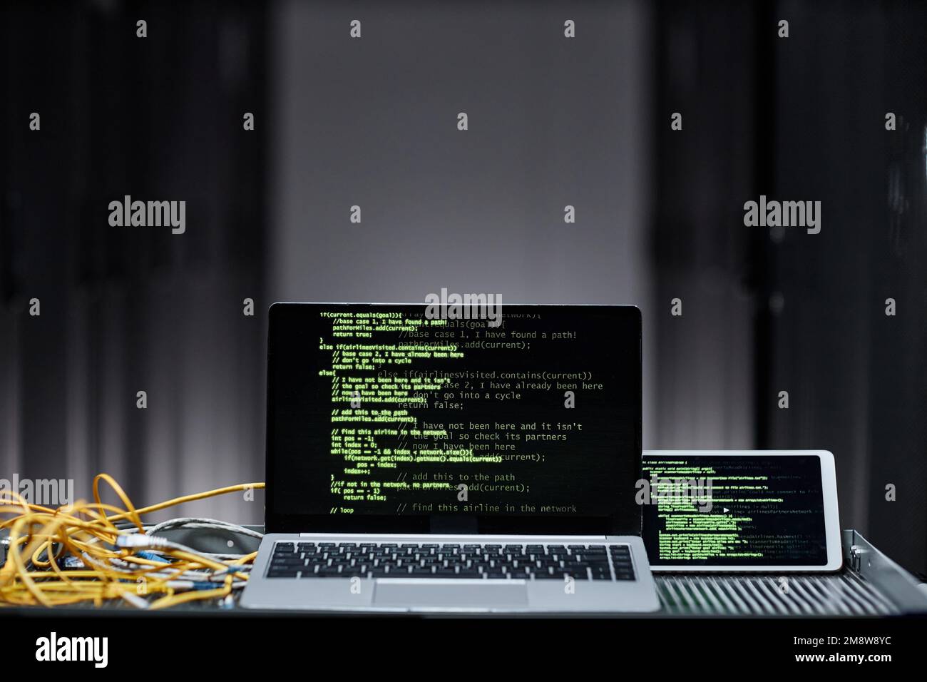 Immagine di sfondo minima del computer portatile con righe di codice verdi sullo schermo nella sala server, sicurezza dei dati, spazio di copia Foto Stock