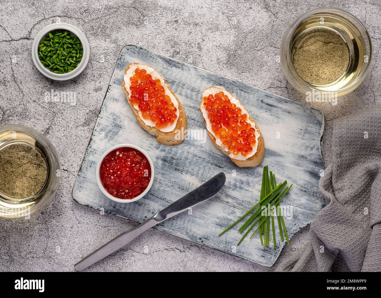 Fotografia gastronomica di sandwich con caviale, erba cipollina, vino bianco, antipasto, delicatezza Foto Stock