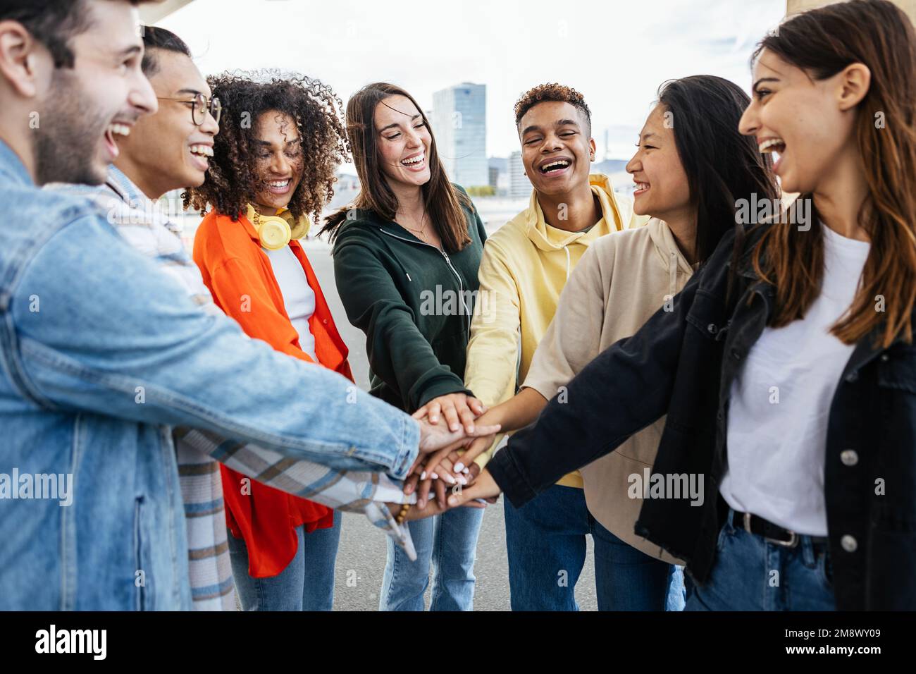 Diversi studenti adolescenti amici impilando le mani mostrando lavoro di squadra e cooperazione Foto Stock