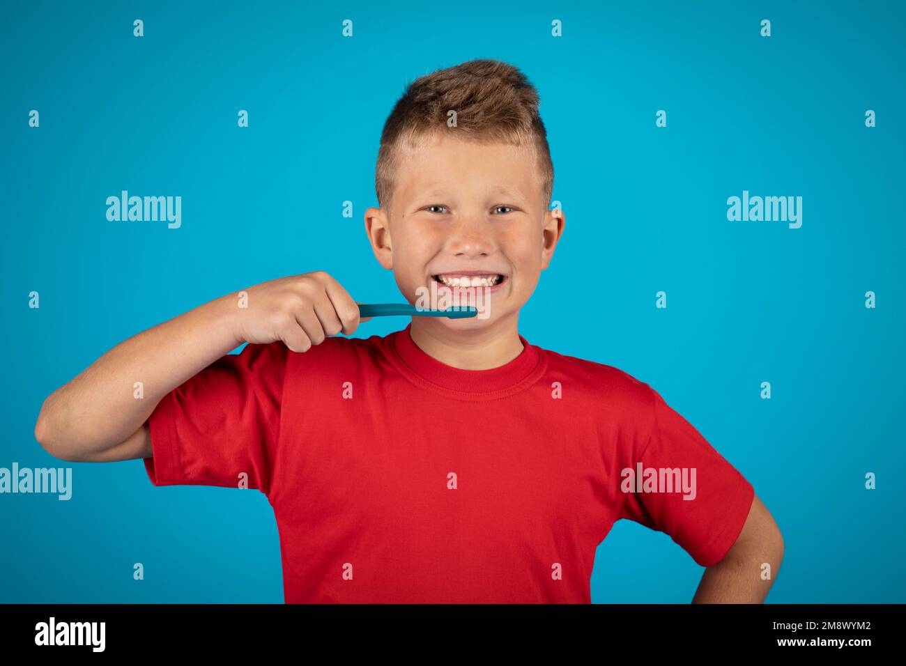 Buon ragazzo con denti spazzolati e sorridente alla fotocamera Foto Stock