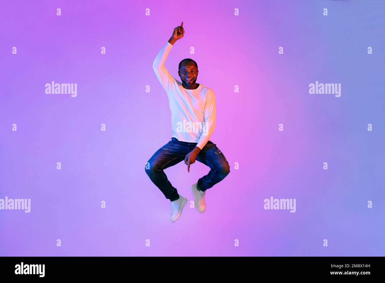 Divertente uomo afroamericano che salta in aria e gesturing Foto Stock