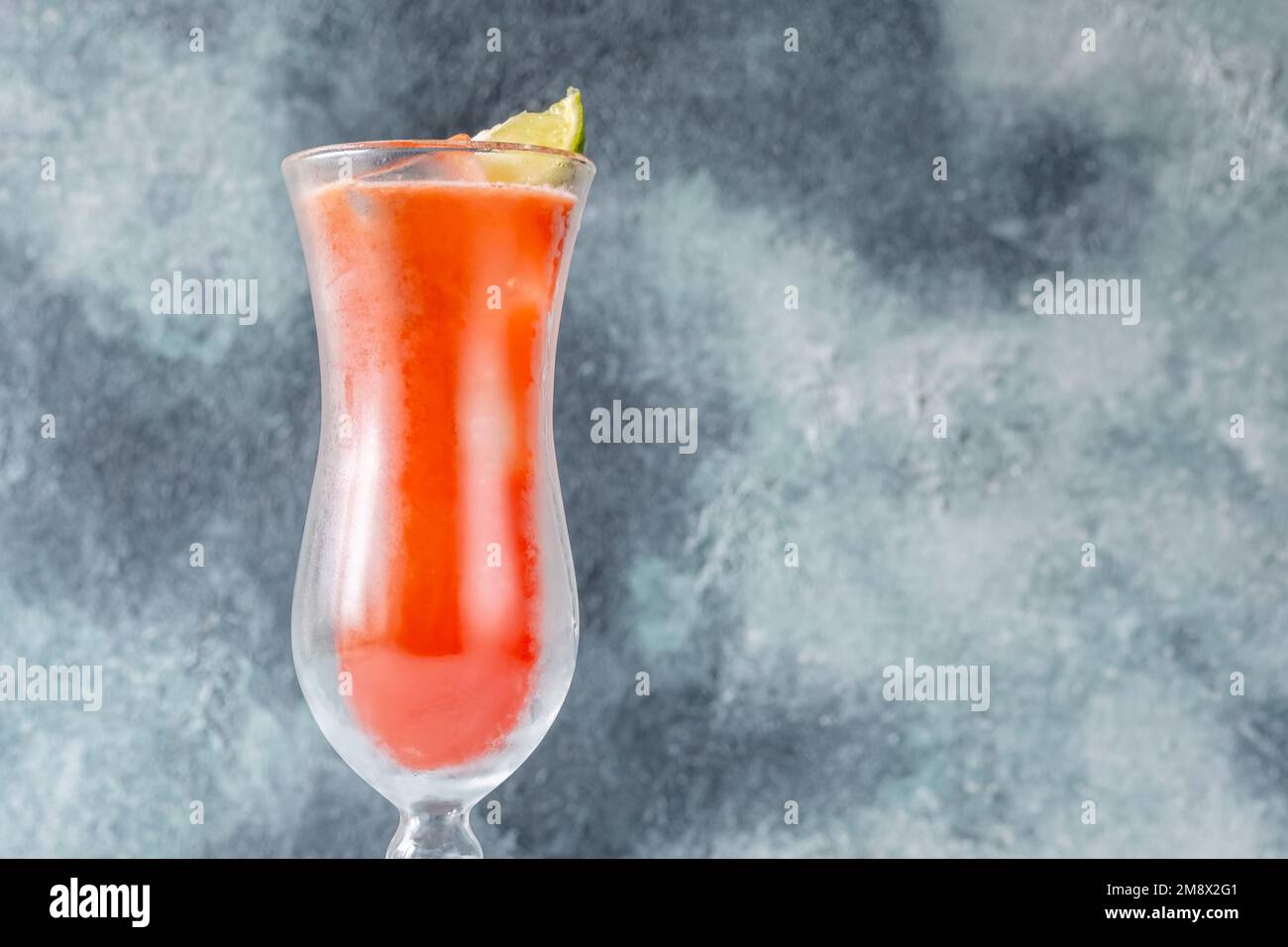 Bicchiere di Koolaid cocktail guarnito con zeppa di lime Foto Stock