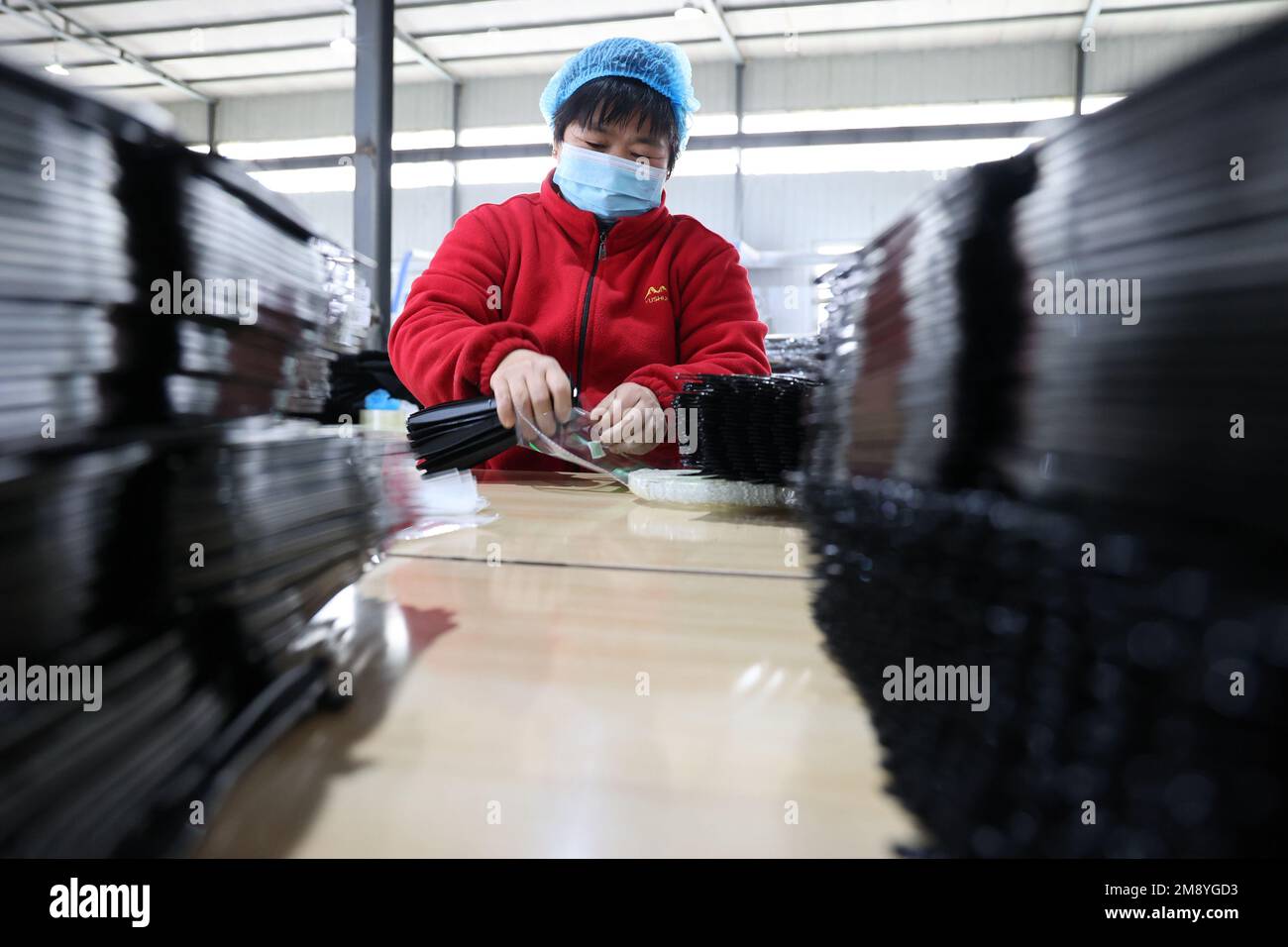 BINZHOU, CINA - 16 GENNAIO 2023 - i lavoratori si affrettano a fare ordini all'estero in un workshop di un'azienda di imballaggio alimentare in plastica a Binzhou, SH della Cina orientale Foto Stock