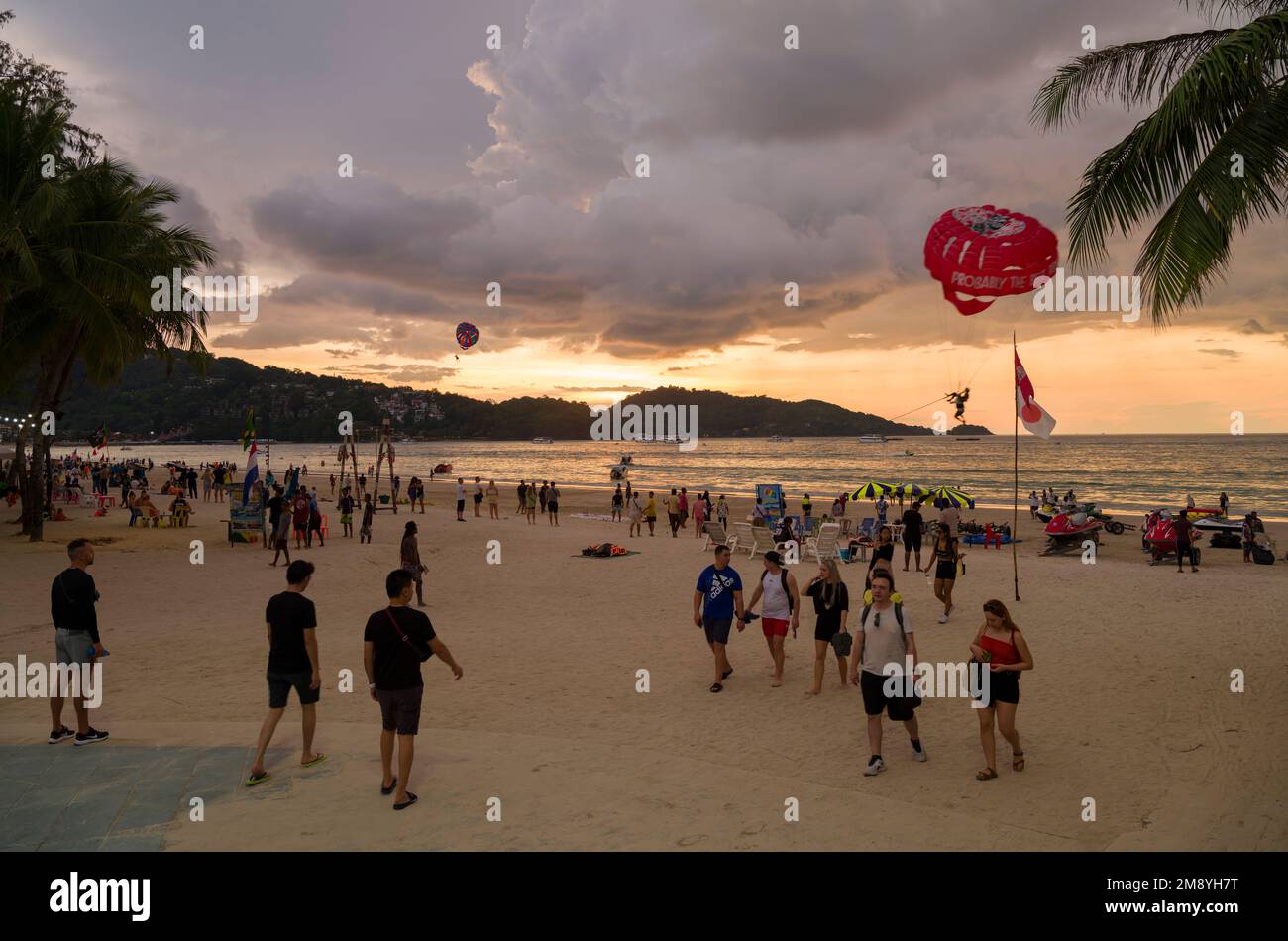 Patong Beach, Phuket, Thailandia - 29 novembre 2022. Spiaggia di Patong al tramonto. Turisti che camminano sulla spiaggia di sera. La famosa spiaggia della Thailandia Foto Stock