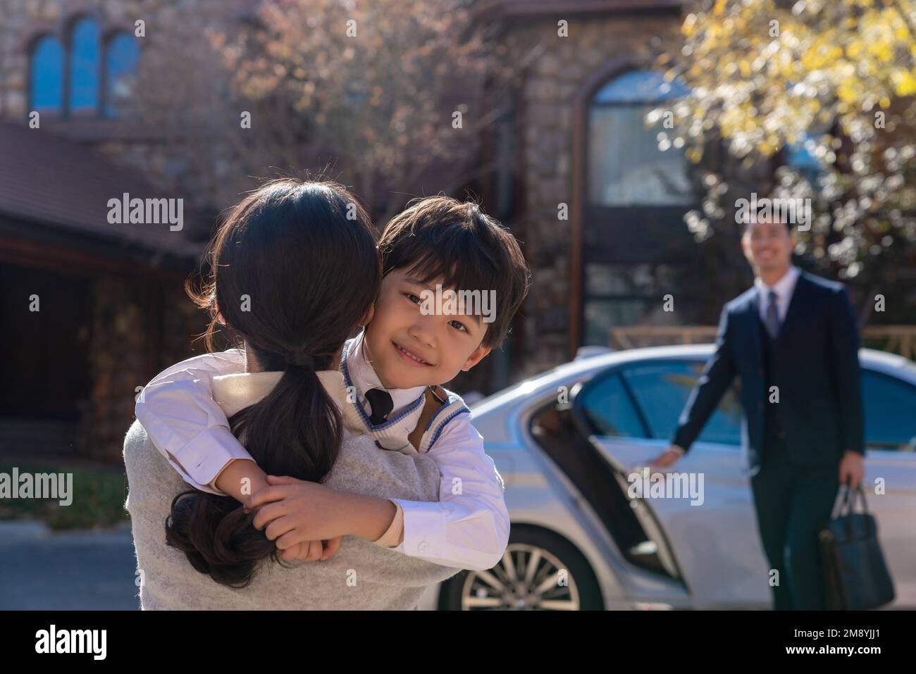 Una giovane coppia preleva i bambini dalla scuola Foto Stock