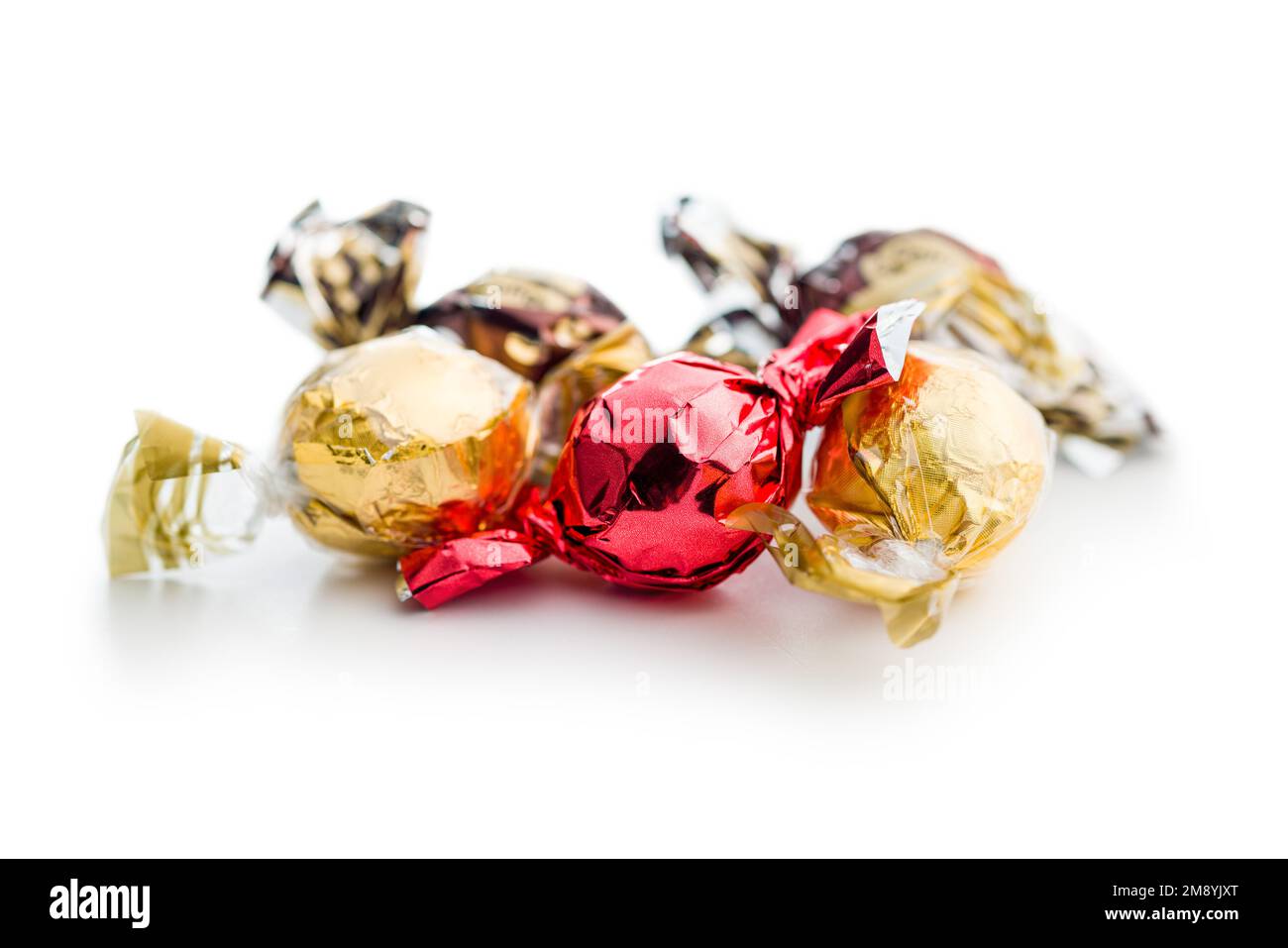 Caramelle dolci avvolte in foglio isolato su sfondo bianco. Foto Stock