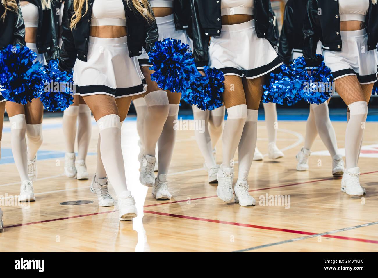 Shot livello ginocchio. Un gruppo di cheerleaders in gonne bianche e gambaletti. Sport cocnept. Foto di alta qualità Foto Stock