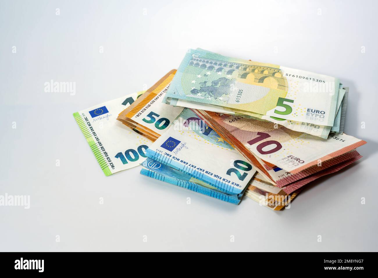 Stack di diverse banconote in euro su sfondo grigio chiaro, concetto di business, finanza, inflazione ed economia, spazio copia, messa a fuoco selezionata, stretta Foto Stock