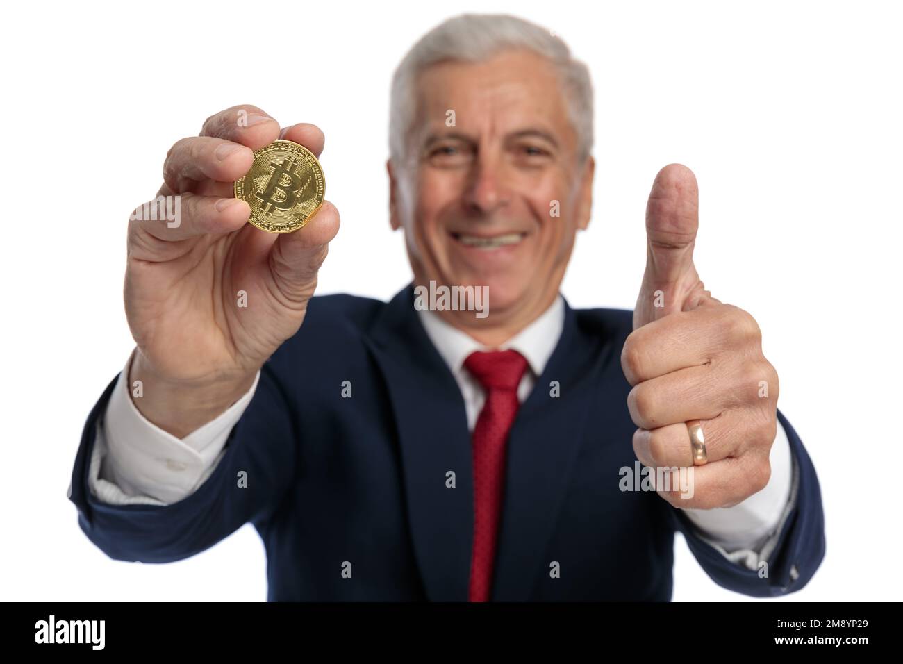 vecchio uomo d'affari che mostra un bitcoin e gesturing che è ok investire in questo criptokin Foto Stock