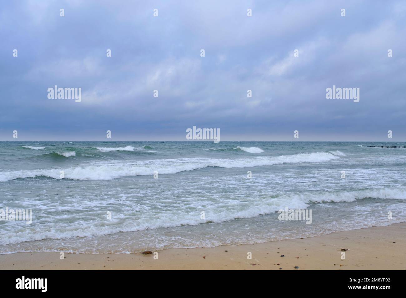 Onde ondulate sulla spiaggia sabbiosa del Mar Baltico Foto Stock