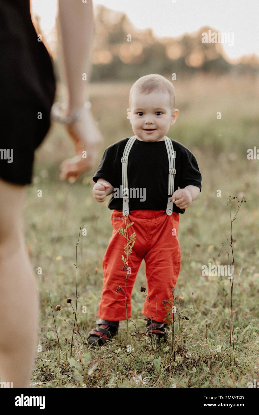 il piccolo bambino cute sorride la sua madre nell'estate di campo. La grana aggiunta simula la pellicola Foto Stock