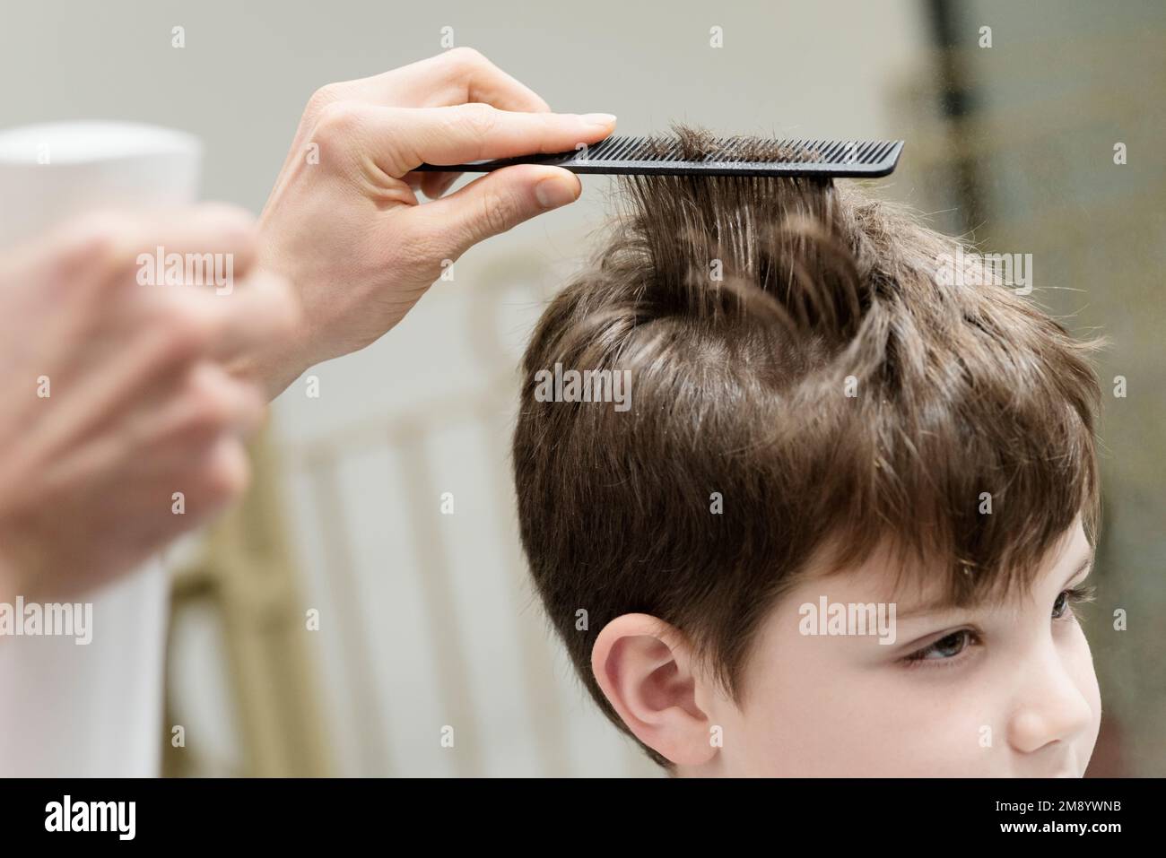 Un piccolo ragazzo in un parrucchiere Salon Foto Stock