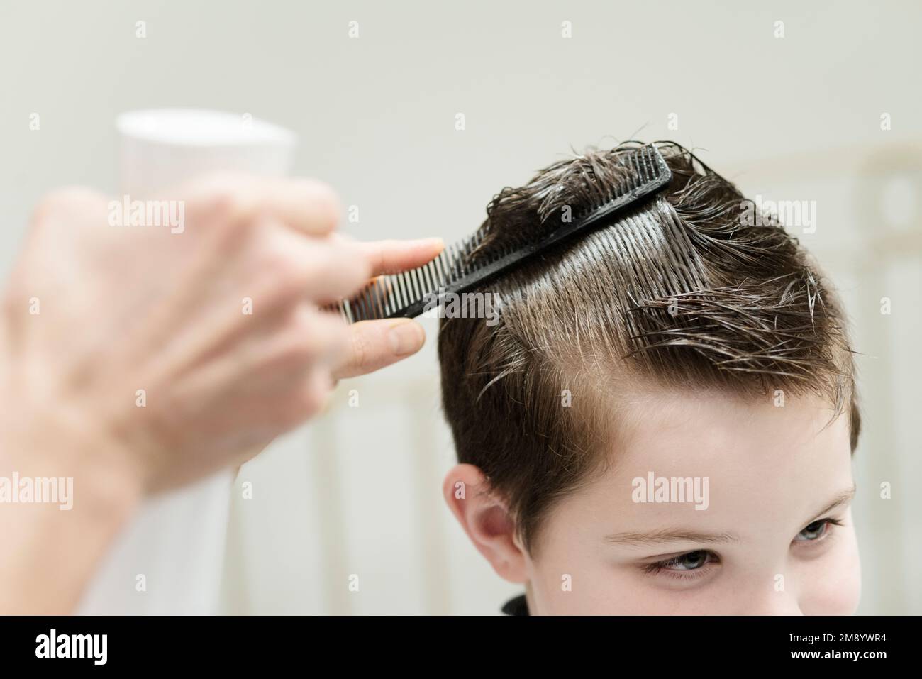 Un piccolo ragazzo in un parrucchiere Salon Foto Stock
