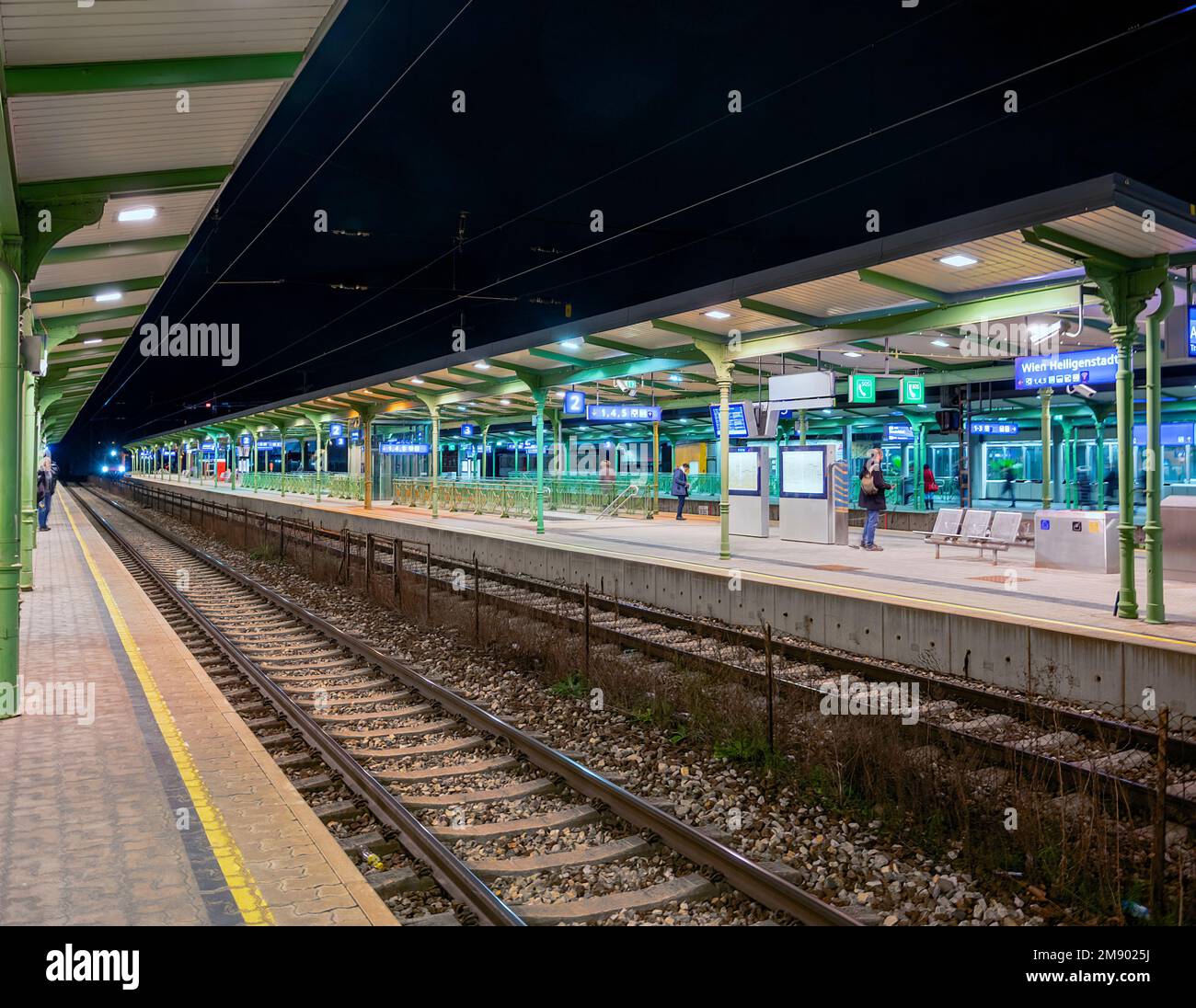 Stazione ferroviaria storica illuminata dal famoso architetto otto Wagner e moderne piattaforme metropolitane a Vienna-Heiligenstadt di notte Foto Stock