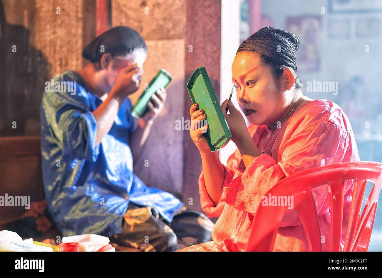 L'attore dell'opera cinese cosmetica fa il viso da dipingere prima di esibirsi nella fase posteriore del teatro Foto Stock