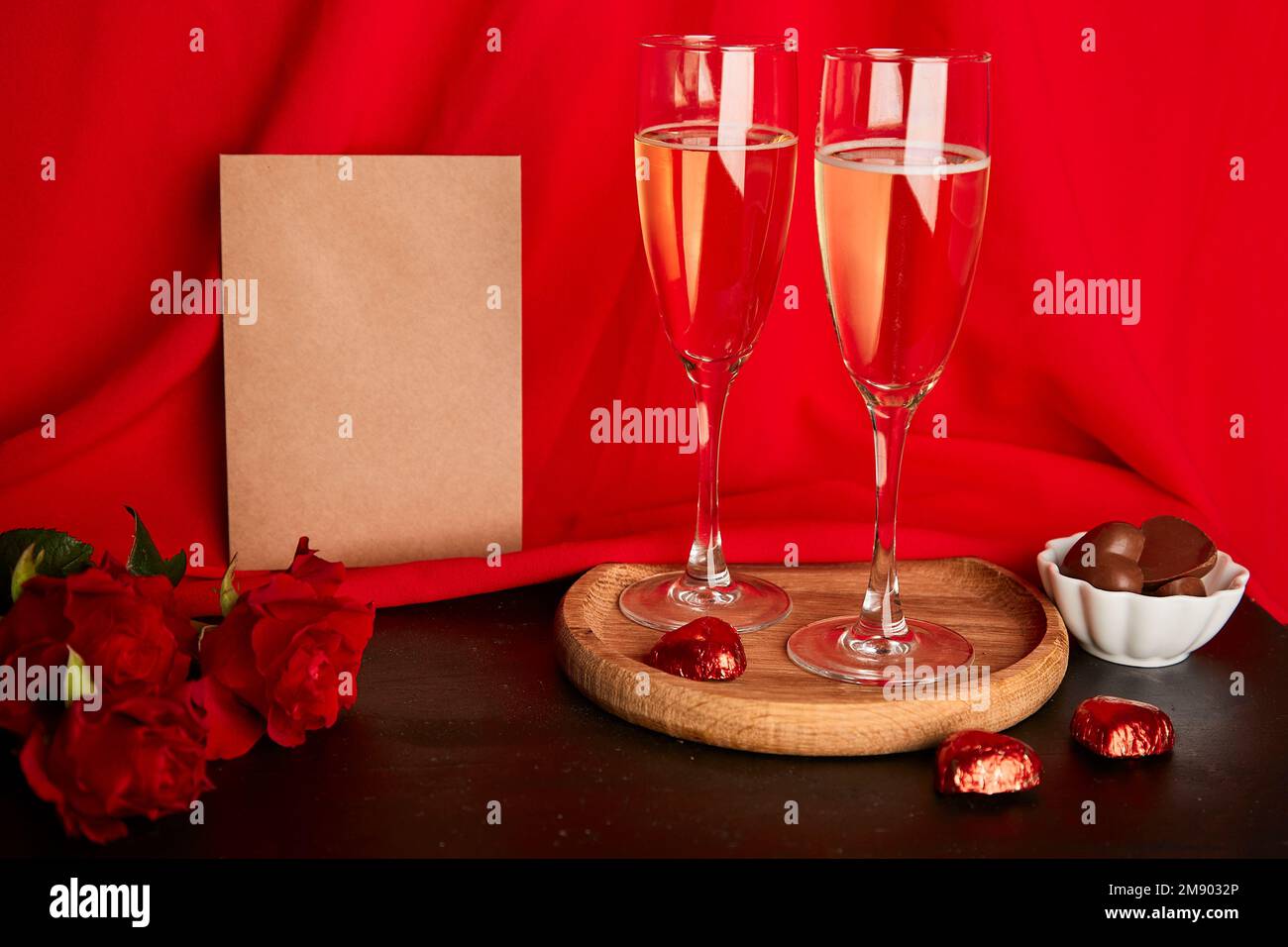 La cartolina del mestiere di San Valentino estetica di giorno in su. Cena romantica stagionale alla moda con cartolina, champagne, rose e caramelle al cioccolato. Foto Stock