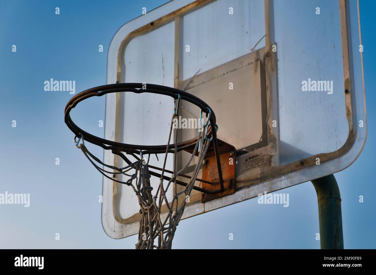 Il canestro da basket e il backboard trascurati contro un cielo blu, Bakersfield California Foto Stock