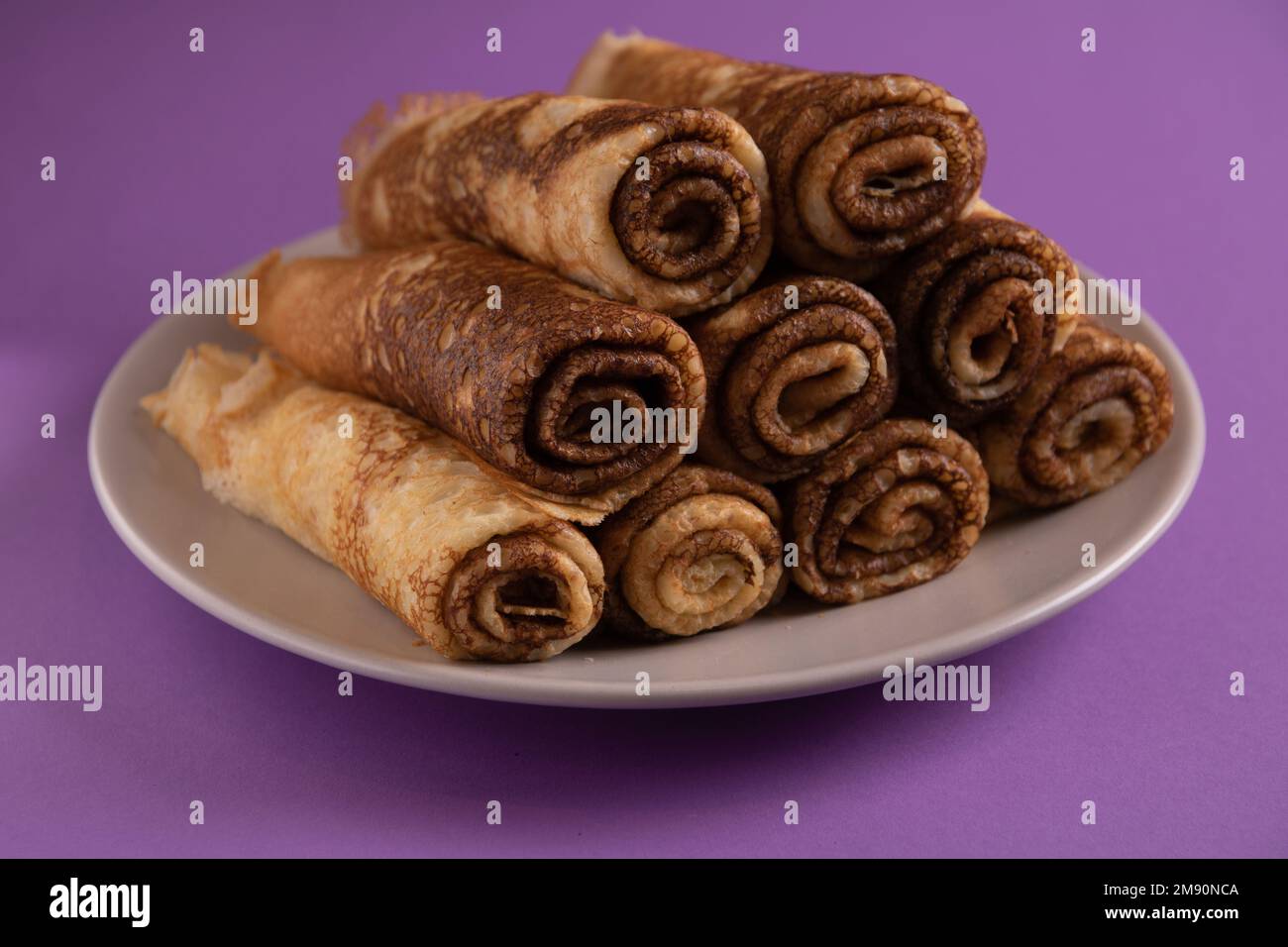 foto di molti frittelle fritte arrotolate su un piatto su uno sfondo colorato Foto Stock