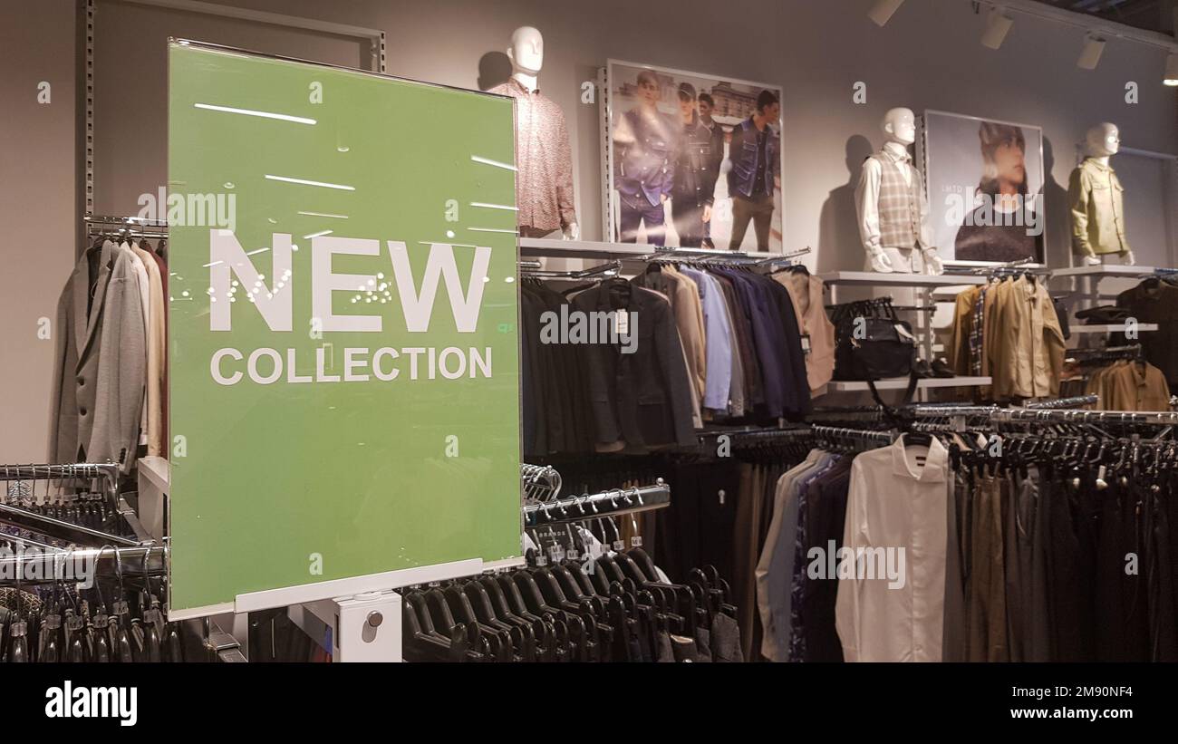 Un cartello in un negozio di abbigliamento da uomo con una NUOVA COLLEZIONE  di cartelli con luci. Negozio di lusso concettuale, centro commerciale,  vendita al dettaglio, outlet Foto stock - Alamy