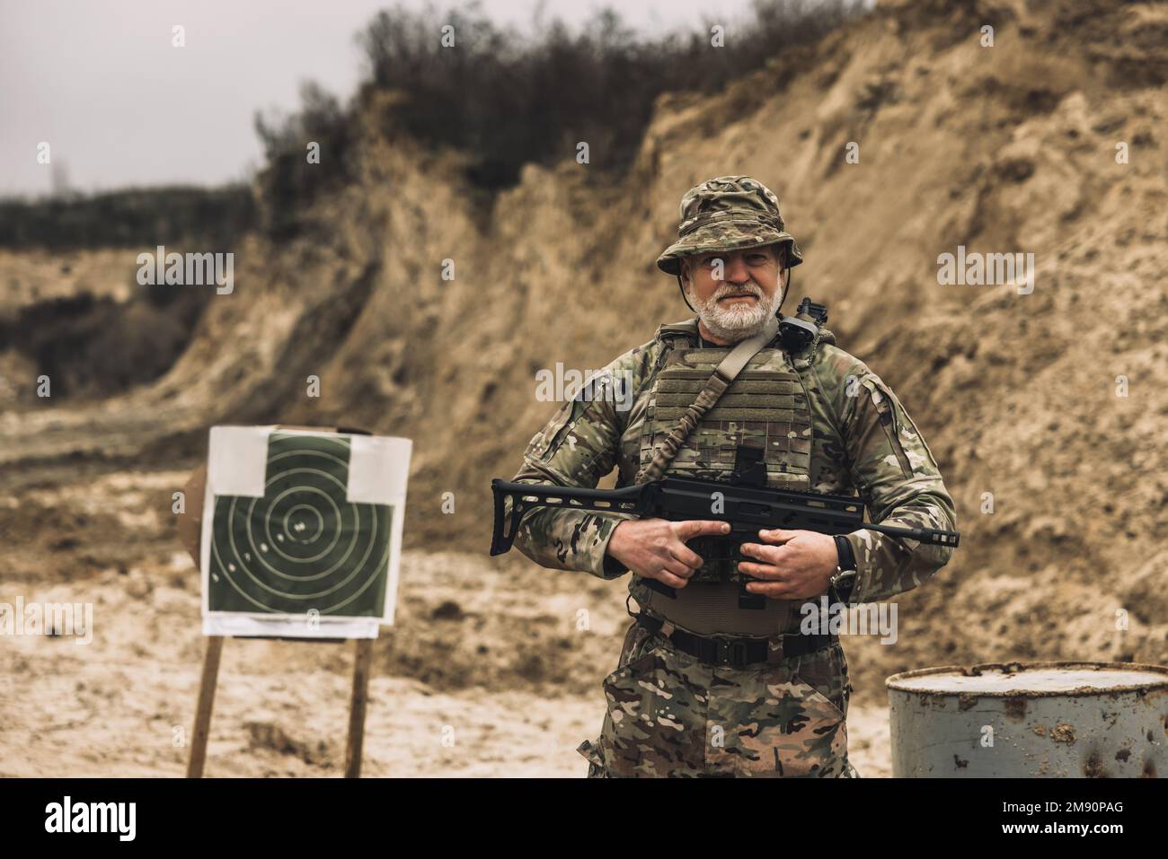 Soldato maturo con un fucile in mano su un campo di tiro Foto Stock