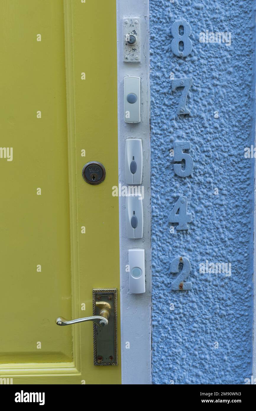 Fila di pulsanti campanello accanto ai numeri su una parete all'esterno di un edificio per diversi appartamenti nello stesso edificio Foto Stock