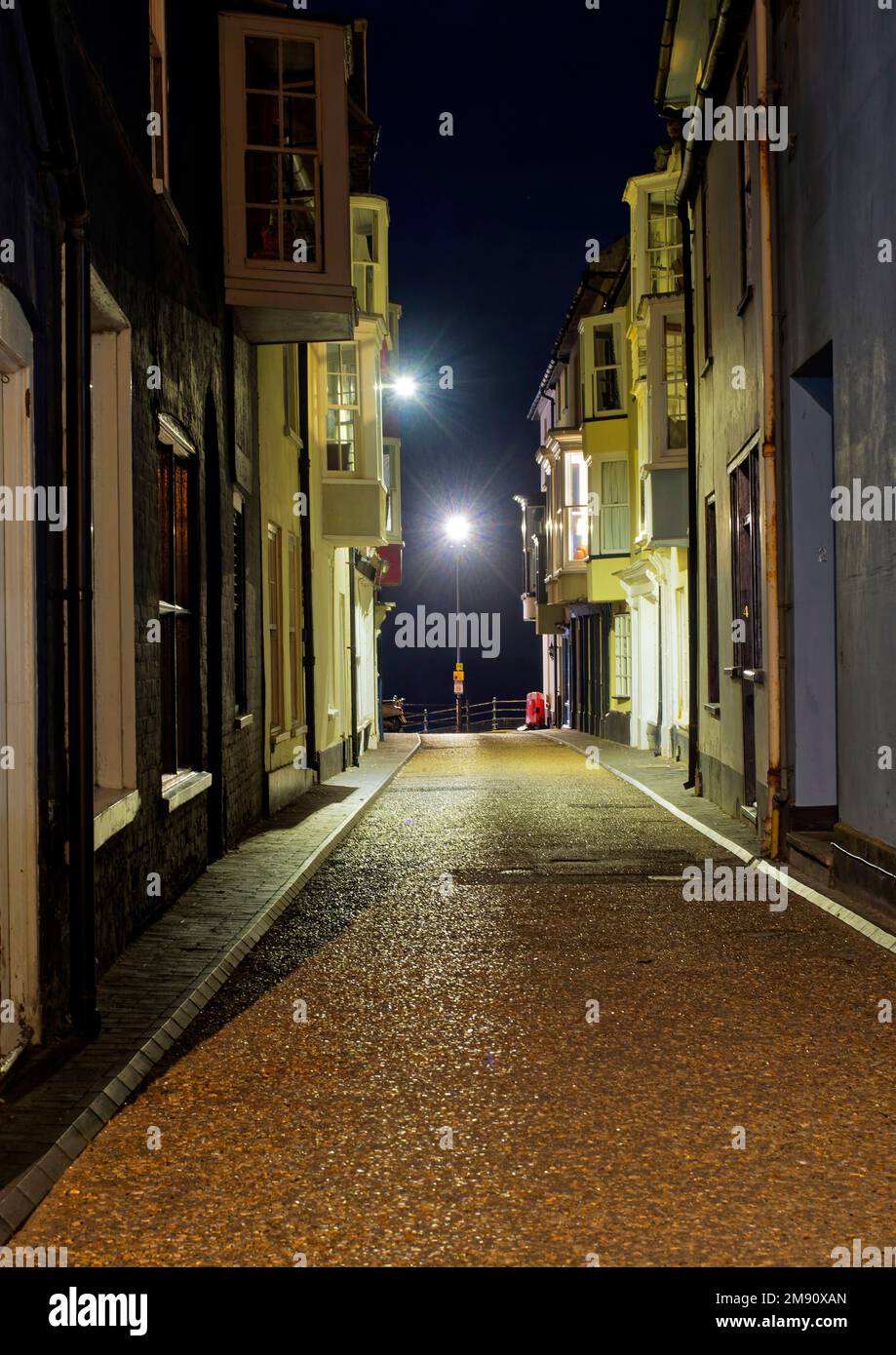 Jetty Street a Cromer nel Nord Norfolk di notte in una fredda serata autunnale con un caldo bagliore da edifici illuminati. Foto Stock