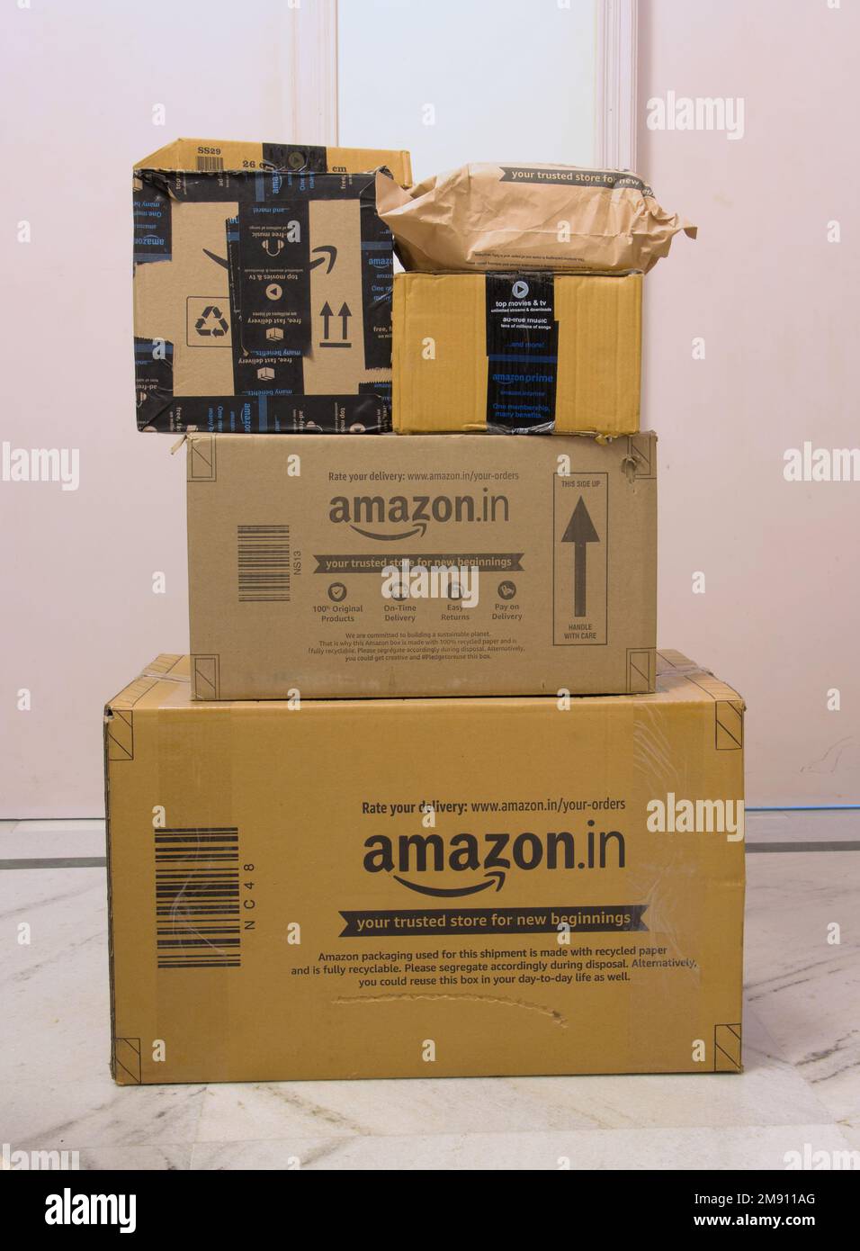 Pacchi impilati da amazon in scatole corrugate marrone e pacchetti davanti  alla porta Foto stock - Alamy