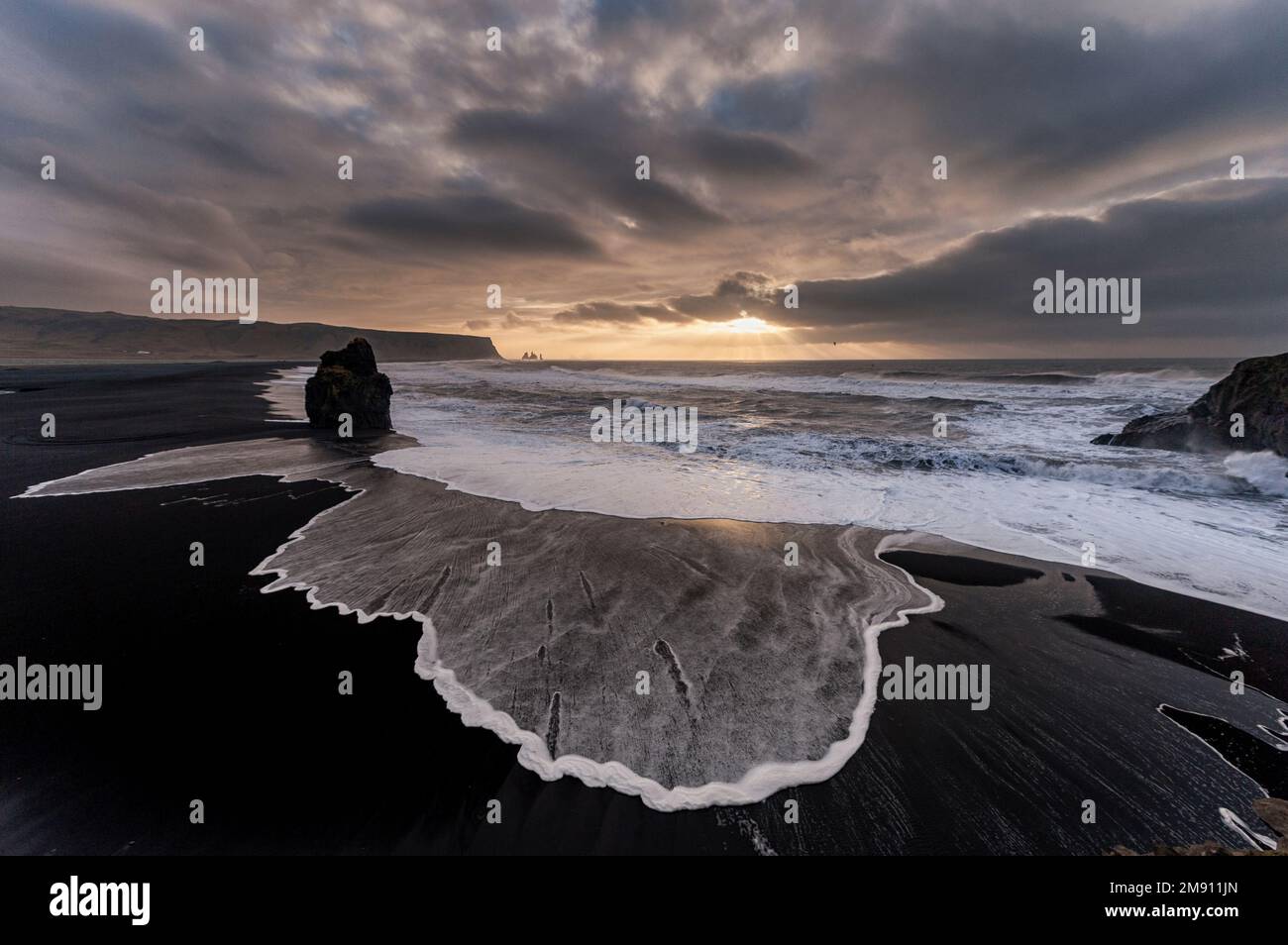 Spiaggia di sabbia nera Reynisfjara in Islanda. Mattina ventosa. Onde oceaniche. Dyrholaey Foto Stock