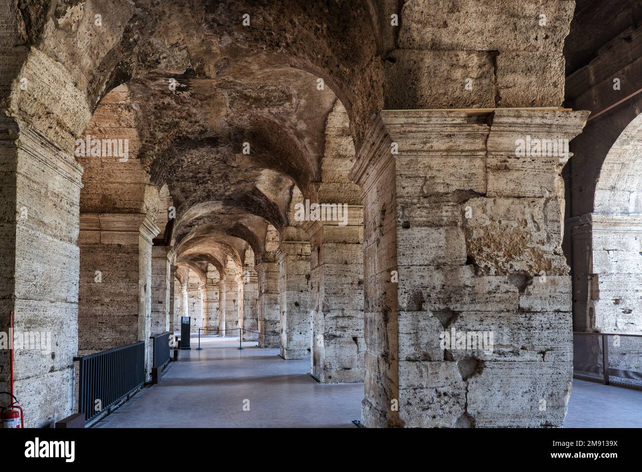 Corridoio con antiche colonne in pietra e archi al piano superiore dell'interno del Colosseo a Roma. Foto Stock