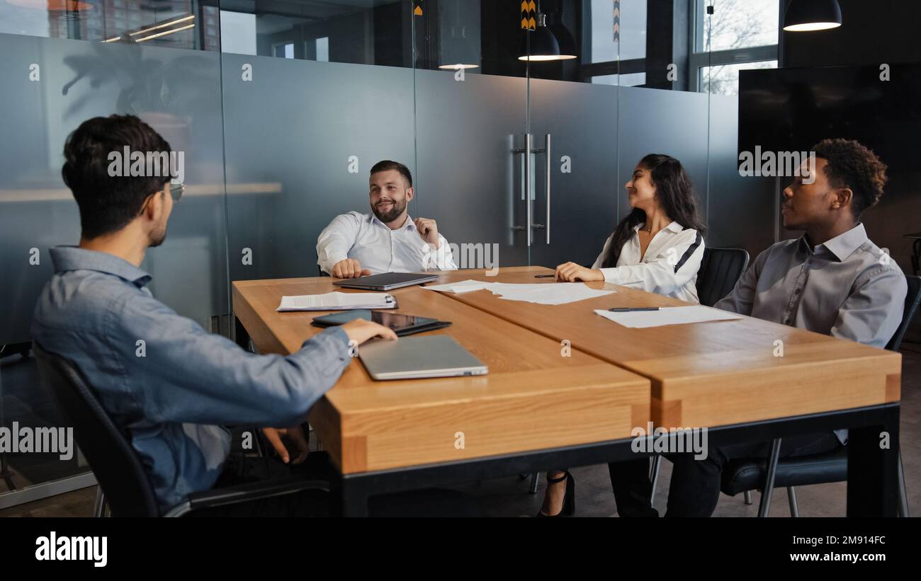 Riunione d'ufficio i dipendenti multirazziali collaborano lavoro di squadra discutono del team aziendale di progetto sviluppatori IT multietnici persone diverse all'interno dell'azienda Foto Stock