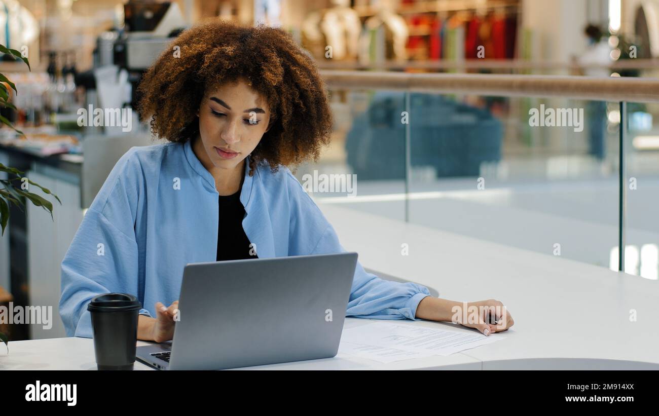 afroamericano studente ragazza millennial business donna freelancer femmina utente manager seduto al tavolo in caffè bere caffè tè di lavoro con Foto Stock