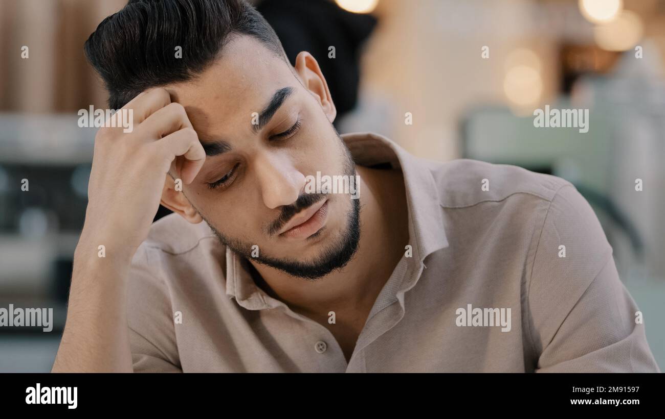 Sottolineato indiano ispanico etnico uomo uomo d'affari uomo maschio che soffre di mal di testa dolore stress doloroso testa problemi di business sovraccarico preoccupazione stanco Foto Stock