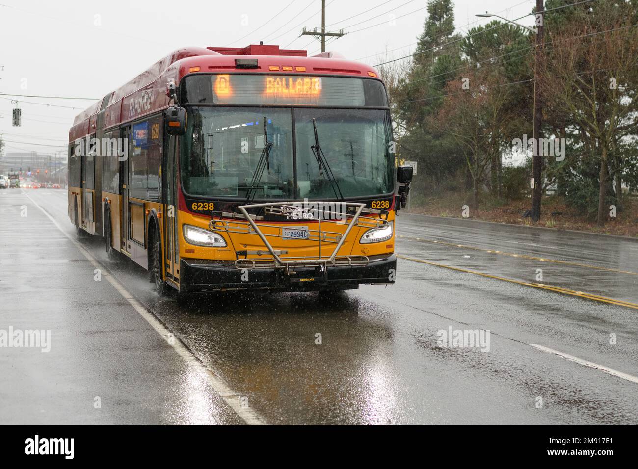 Seattle, WA, USA - 12 gennaio 2023; autobus King County Metro RapidRide per Ballard sulla umida Seattle Street urbana sotto la pioggia Foto Stock